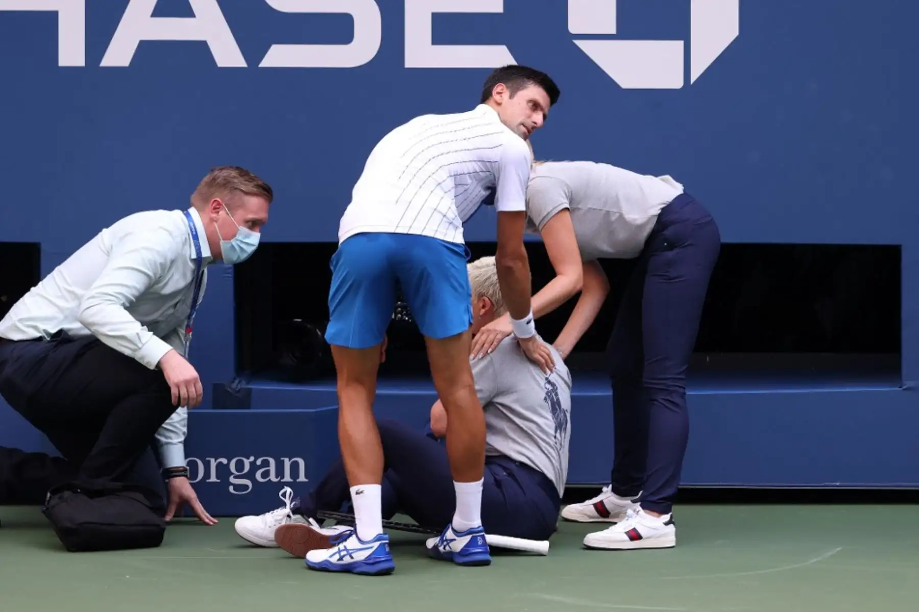 El tenista serbio, Novak Djokovic, atiende a una juez de línea que fue golpeada, sin intención, con la pelota por el propio jugador durante su partido de cuarta ronda de hombres individuales contra Pablo Carreño Busta de España en el séptimo día del Abierto de Estados Unidos 2020. Por esta acción, el jugador fue descalificado del torneo. Foto: AFP