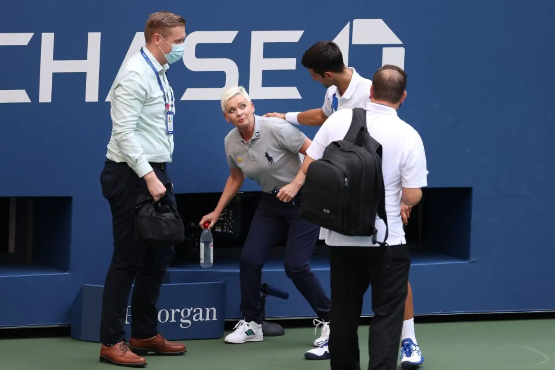 El tenista serbio, Novak Djokovic, atiende a una juez de línea que fue golpeada, sin intención, con la pelota por el propio jugador durante su partido de cuarta ronda de hombres individuales contra Pablo Carreño Busta de España en el séptimo día del Abierto de Estados Unidos 2020. Por esta acción, el jugador fue descalificado del torneo. Foto: AFP