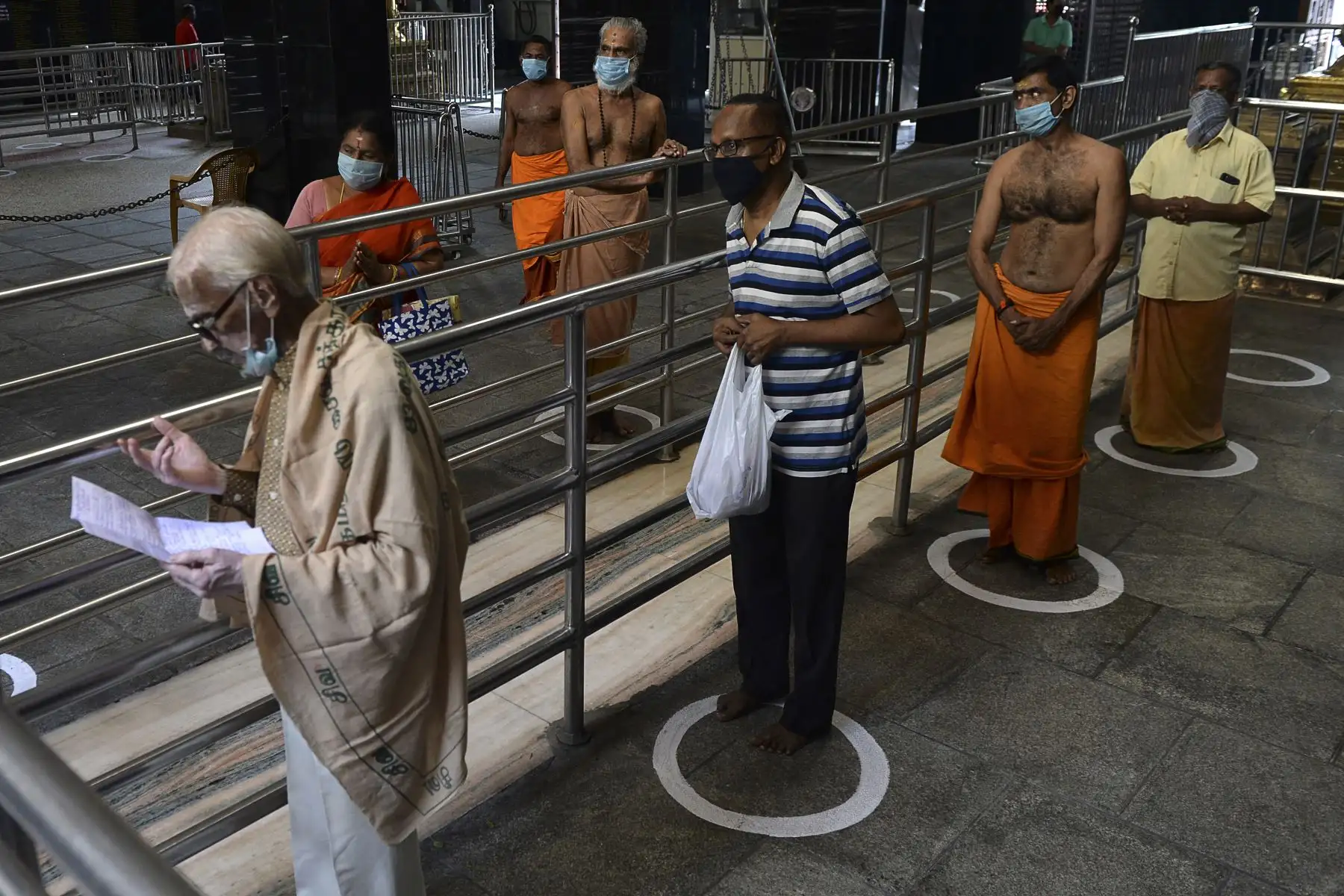 Los devotos hacen cola para mantener el distanciamiento social frente un templo, en Chennai. Foto: AFP