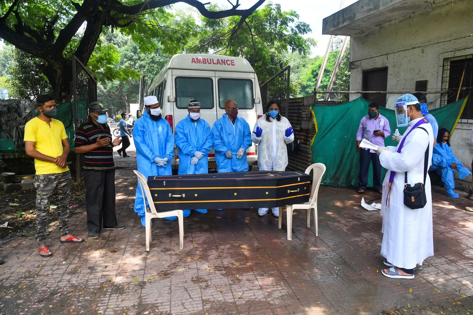El voluntario cristiano Sagai Nair, un pastor y otros grupo de voluntariado musulmán ofrecen una oración frente al ataúd de una víctima del coronavirus, en Pune. Foto: AFP