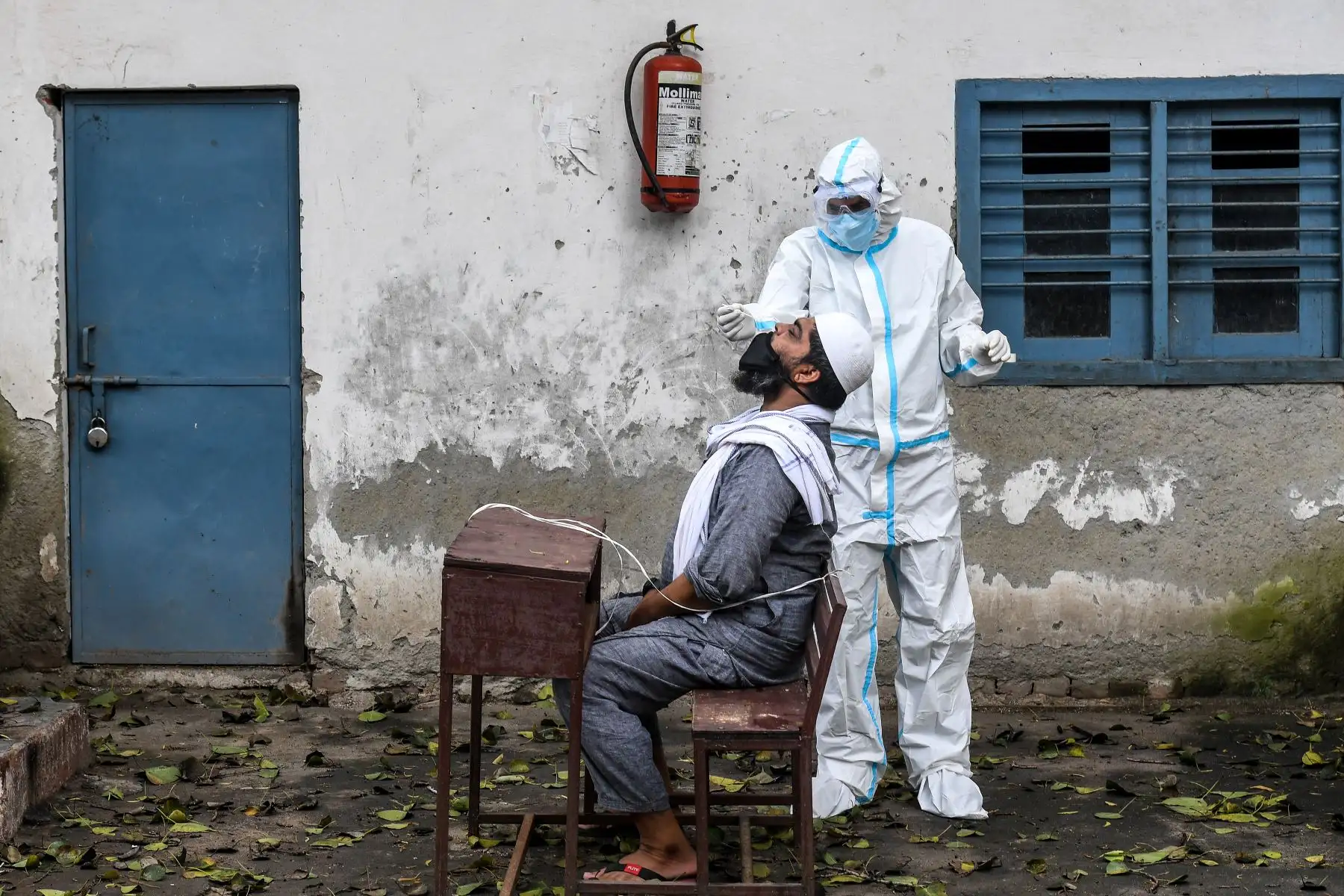 Personal médico toma una muestra de un hombre para detectar la infección por coronavirus. Foto: AFP