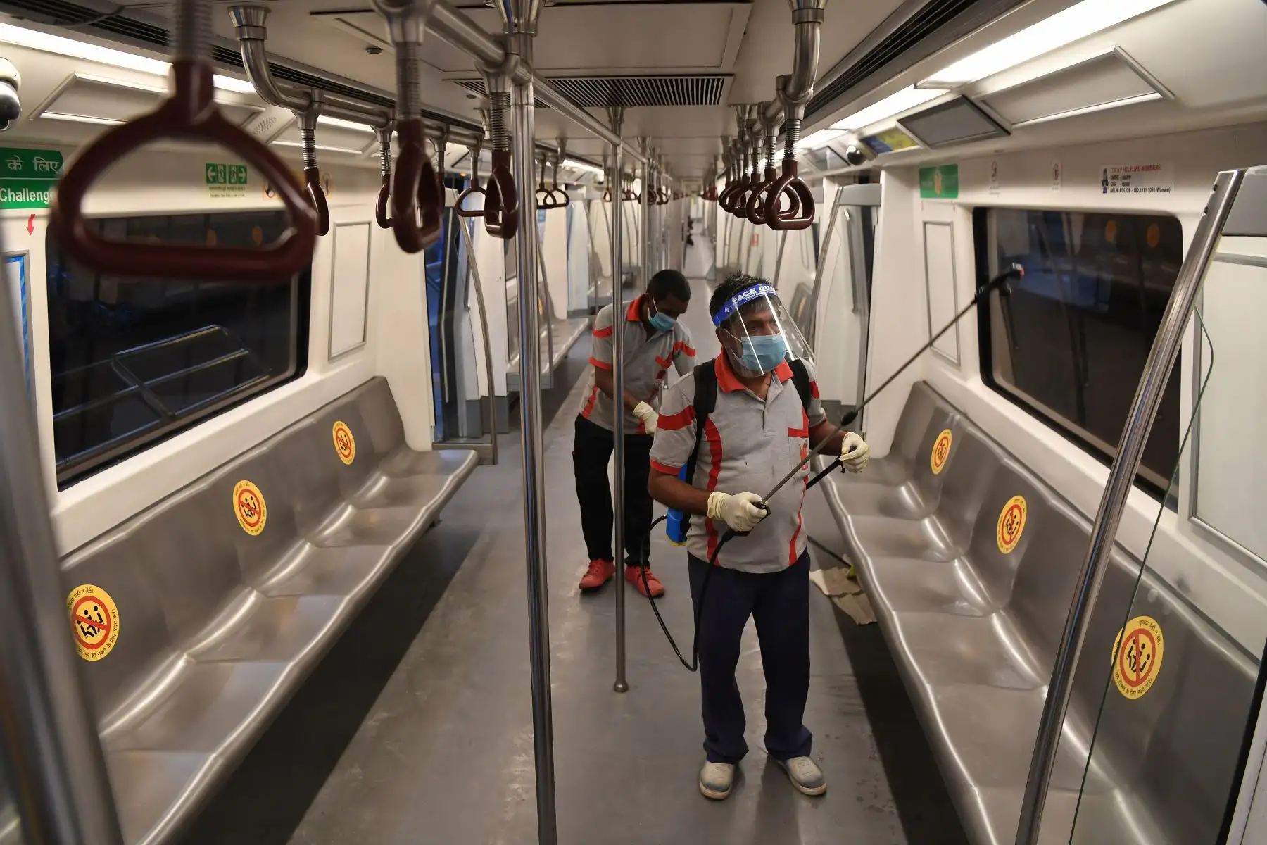 Los empleados de Delhi Metro Rail Corporation desinfectan el interior de un medio transporte para evitar los posibles contagios por coronavirus. Foto: AFP