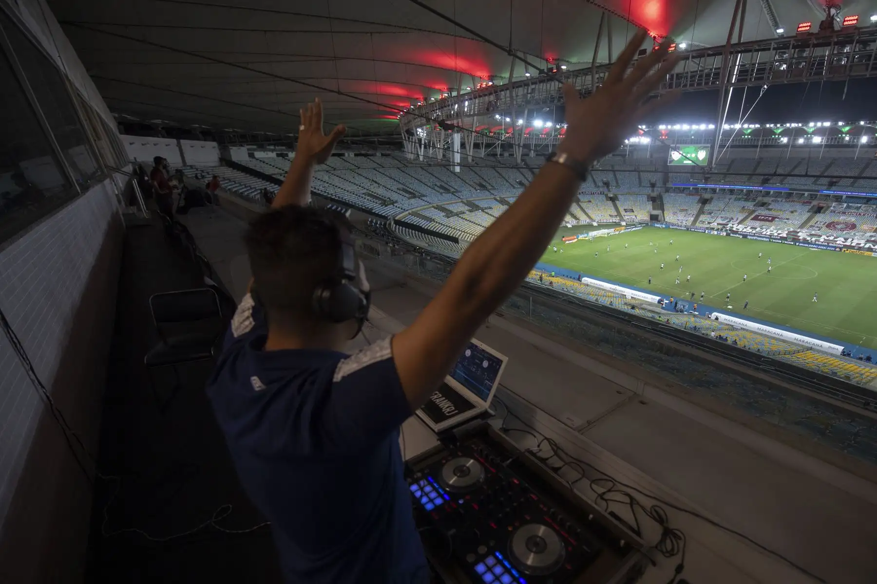 El DJ Franklin Scheleger, de 29 años, reproduce sonidos y canciones que imitan un estadio abarrotado, durante el partido del Campeonato Brasileño entre Fluminense y Atlético Goianiense en el estadio Maracaná de Río de Janeiro, en Brasil. Foto: AFP