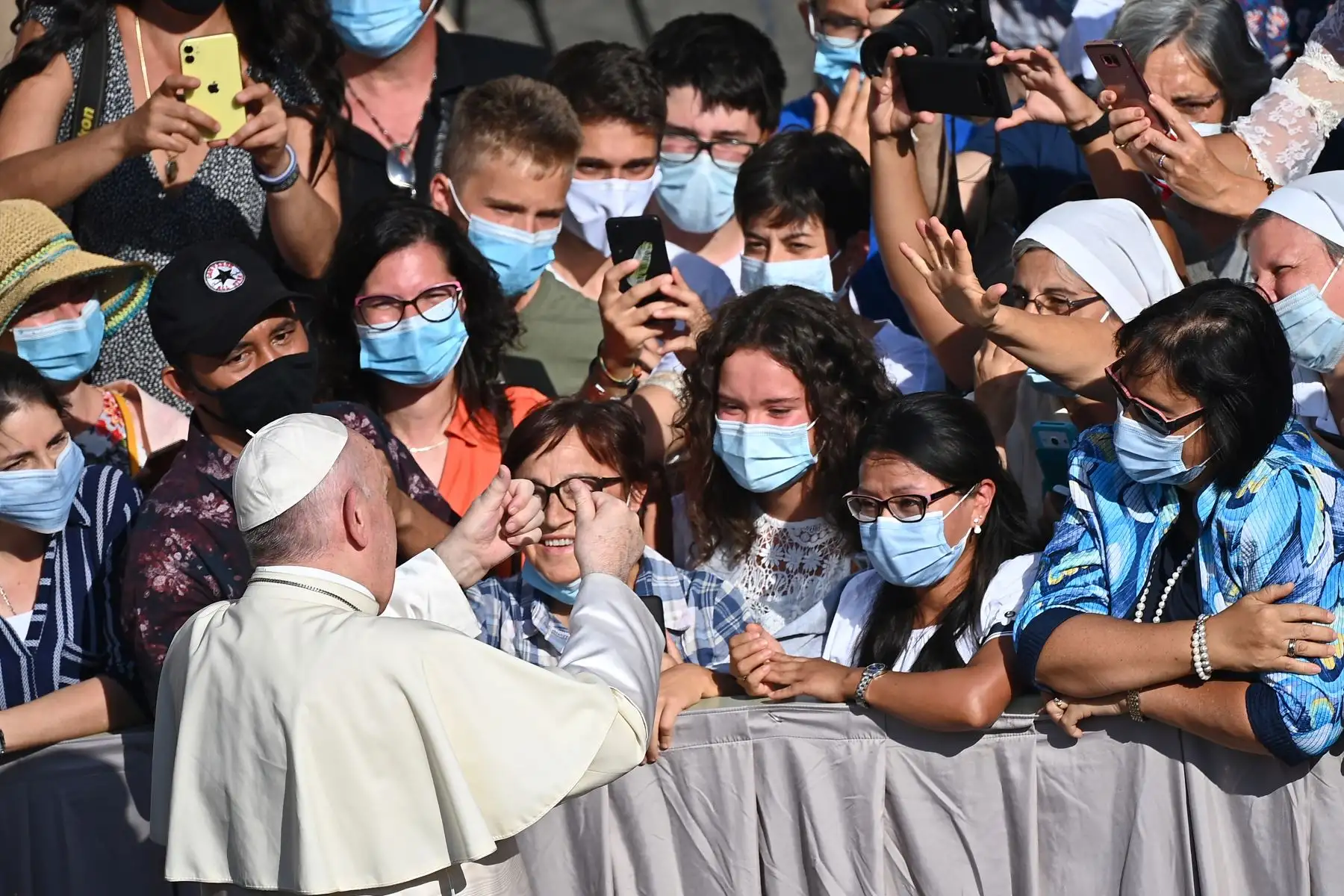 El Papa Francisco se reúne con los asistentes que llevan una mascarilla cuando llega para celebrar una audiencia pública limitada en el patio de San Dámaso, en el Vaticano. Foto: AFP