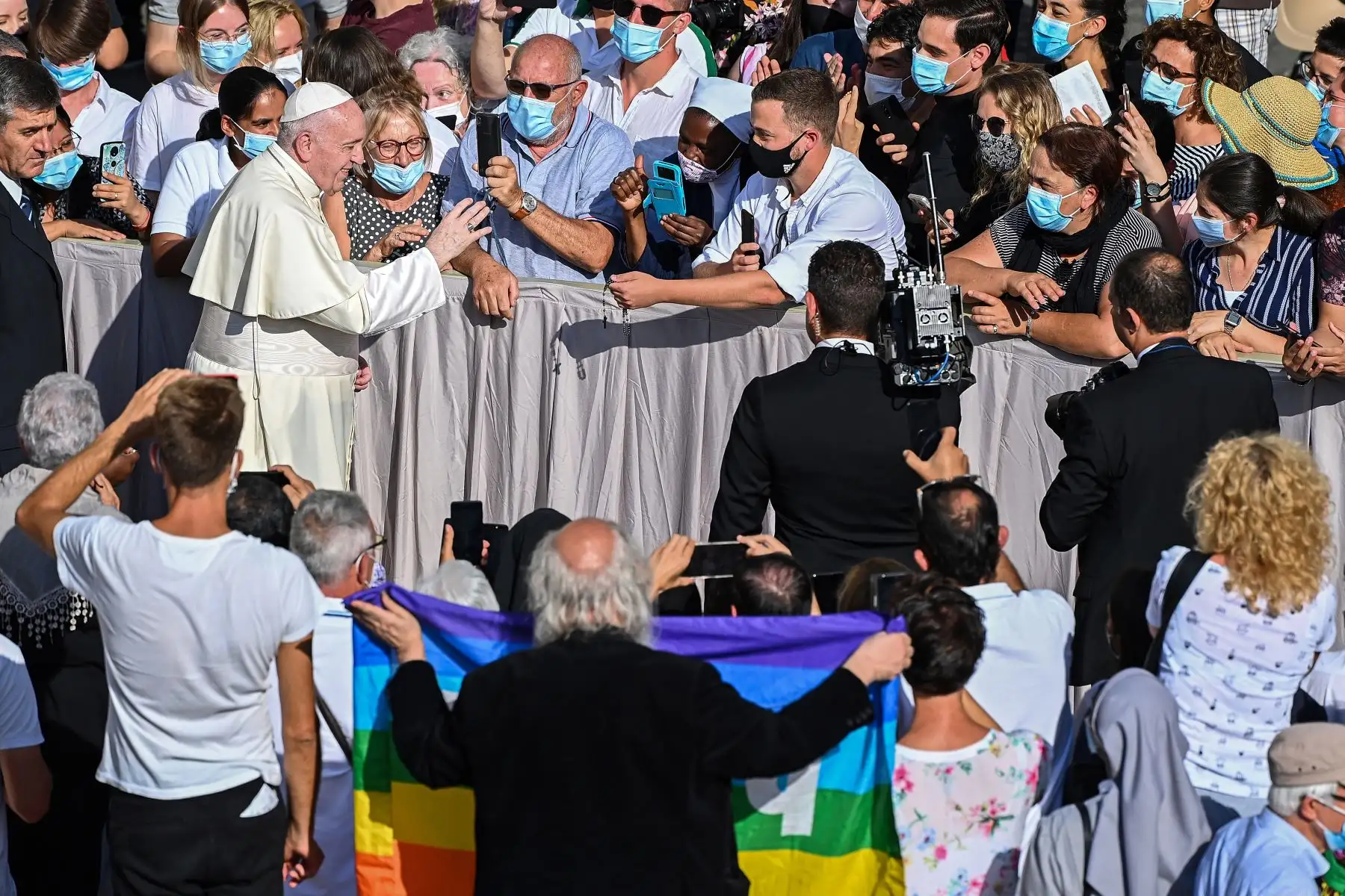 El Papa Francisco se reúne con los asistentes que llevan una mascarilla cuando llega para realizar una audiencia pública limitada en el patio de San Damaso, en el Vaticano. Foto: AFP