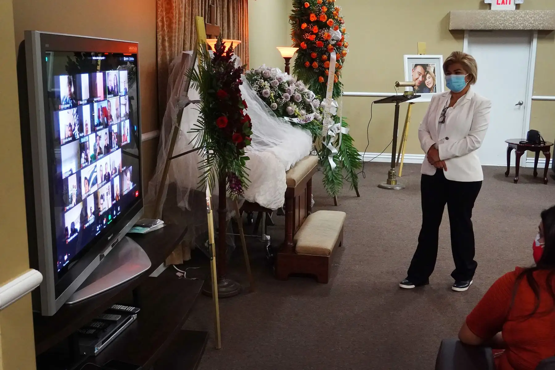 Glena Amaya escucha a familiares y amigos hablar a través de una transmisión de Zoom mientras lloran juntos durante la ceremonia de vigilia de su esposo German Amaya en la Funeraria Maspons, en Miami, Florida. Foto: AFP