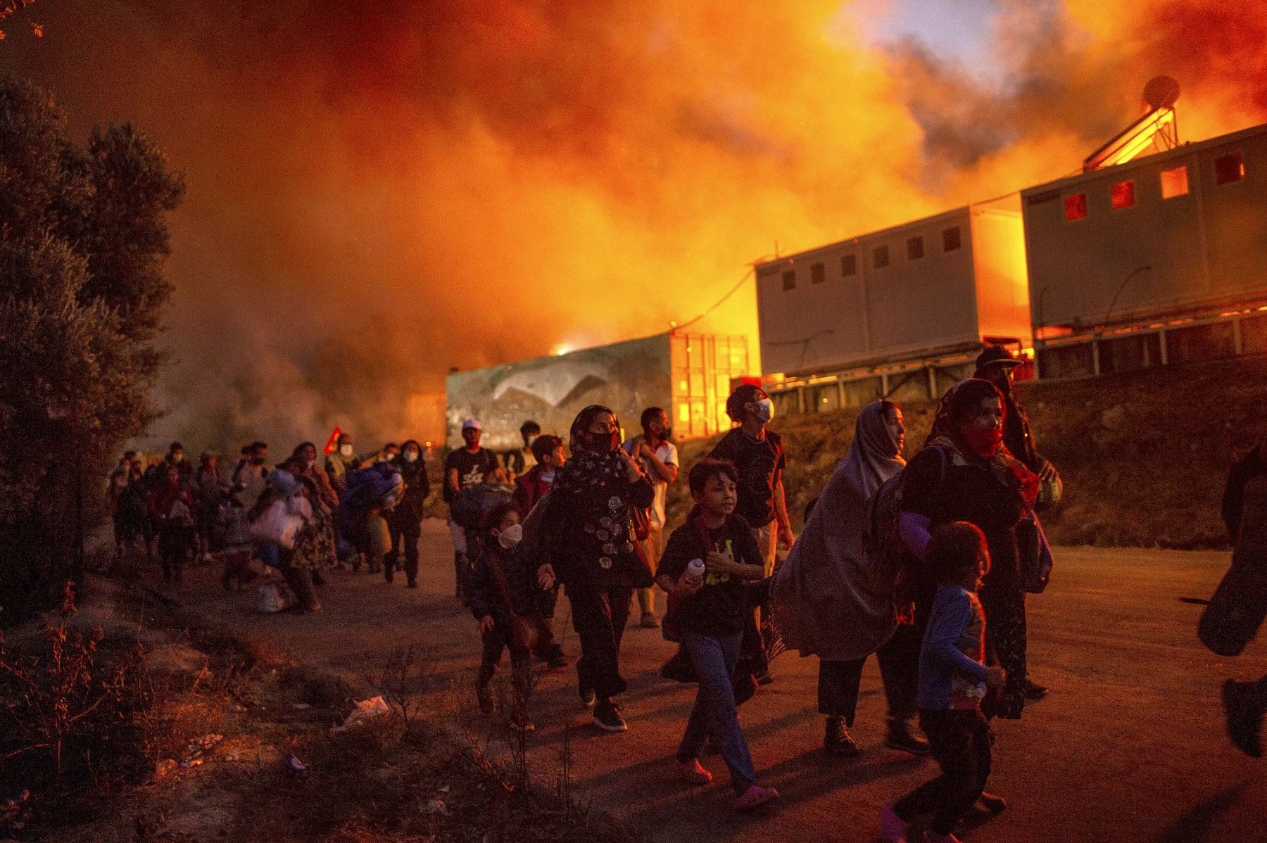 La gente huye de las llamas después de que estallara un gran incendio en el campamento de migrantes de Moria en la isla griega de Lesbos, en el mar Egeo. Foto: AFP
