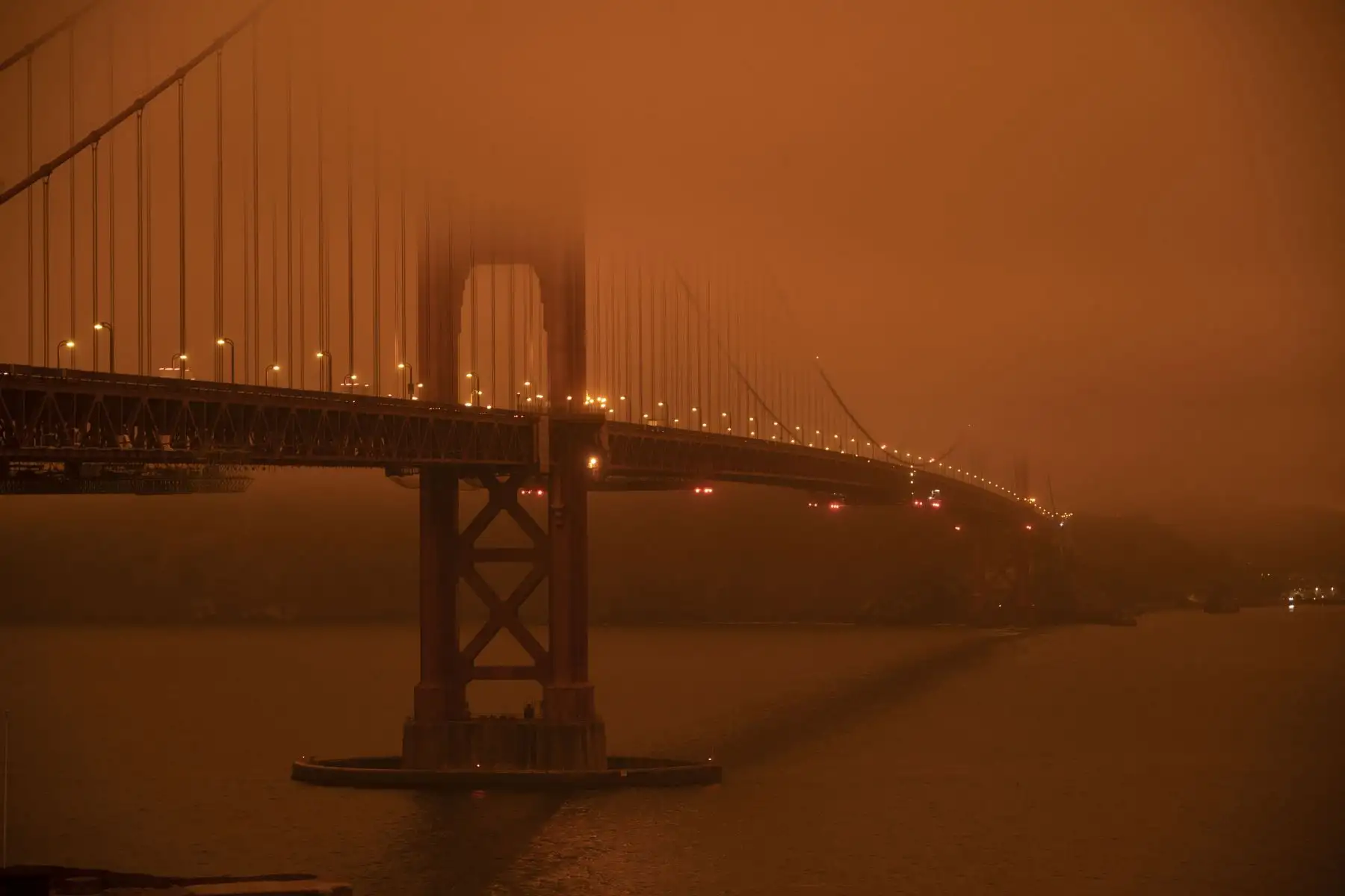 Los autos circulan por el puente de la bahía de San Francisco bajo un cielo lleno de humo naranja al mediodía en San Francisco, California.
Foto: AFP