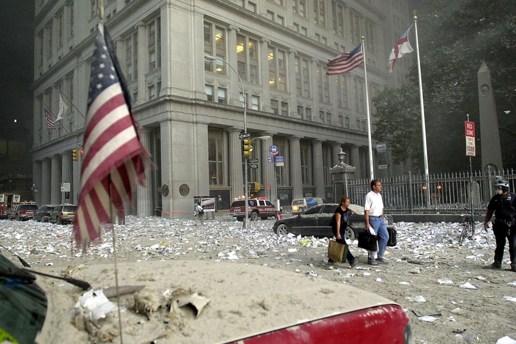 Una pareja camina entre los escombros tras el colapso de una de las torres del World Trade Center el 11 de setiembre de 2001 en Nueva York. Dos aviones secuestrados se estrellaron contra los emblemáticos rascacielos. 
Foto: AFP