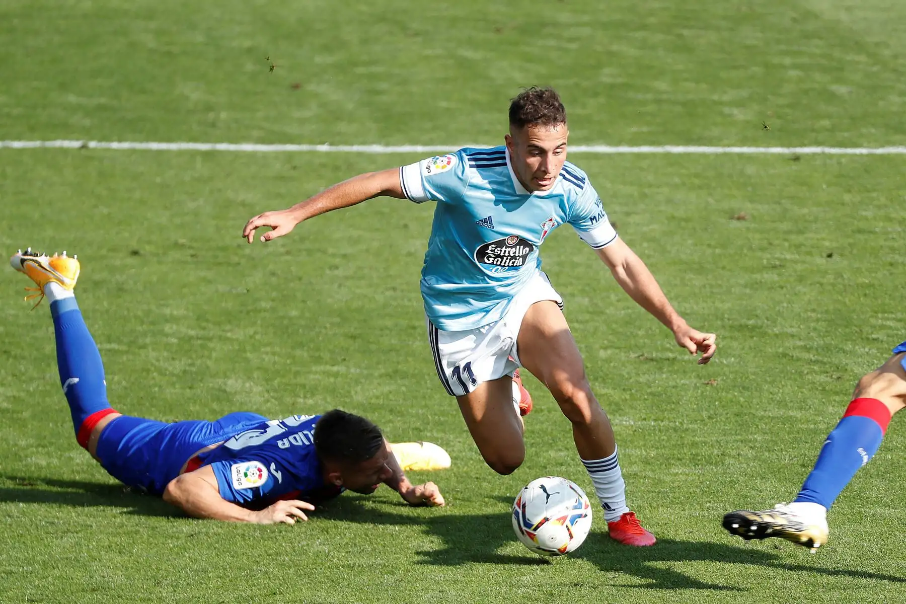Los jugadores del Eibar, el polaco Damian Kadzior y el portugués Paulo Oliveira intentan arrebatar el balón a Emre Mor, Emre Mor, delantero danés del Celta de Vigo, durante el partido de la primera jornada de la LaLiga Santander. Foto: EFE