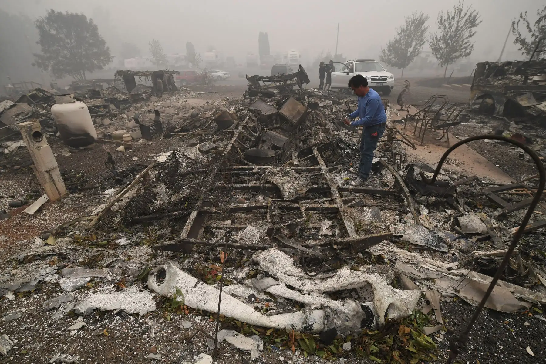 Marcelino Maceda busca artículos en los restos de su casa móvil, en Estacada, Oregón. Foto: AFP