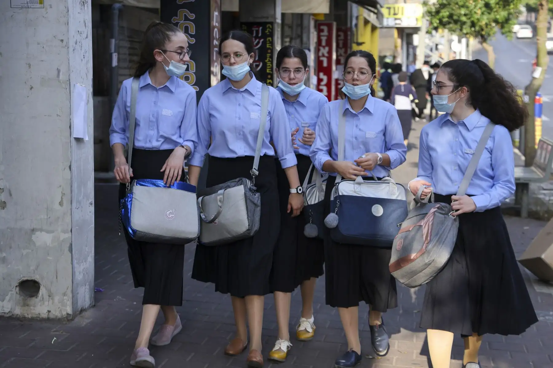 Colegialas judías ultraortodoxas, con máscaras protectoras debido a la pandemia del coronavirus, caminan por una calle en la ciudad de Bnei Brak, cerca de Tel Aviv. Foto: AFP