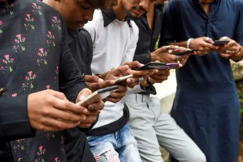 En esta foto tomada el 10 de noviembre de 2019, los jóvenes ven videos en la aplicación TikTok en sus teléfonos móviles en Mumbai, India. Foto: AFP