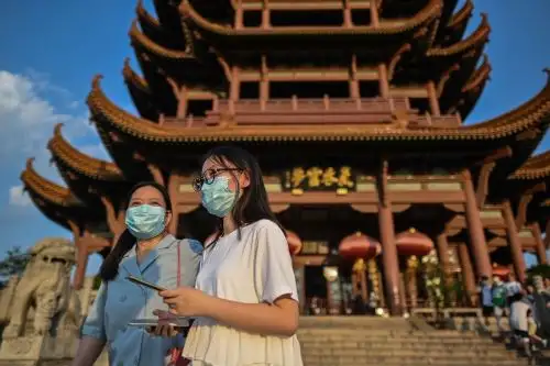 Turistas con máscaras faciales visitan la Torre de la Grulla Amarilla en Wuhan, provincia central de Hubei en China. Foto: AFP