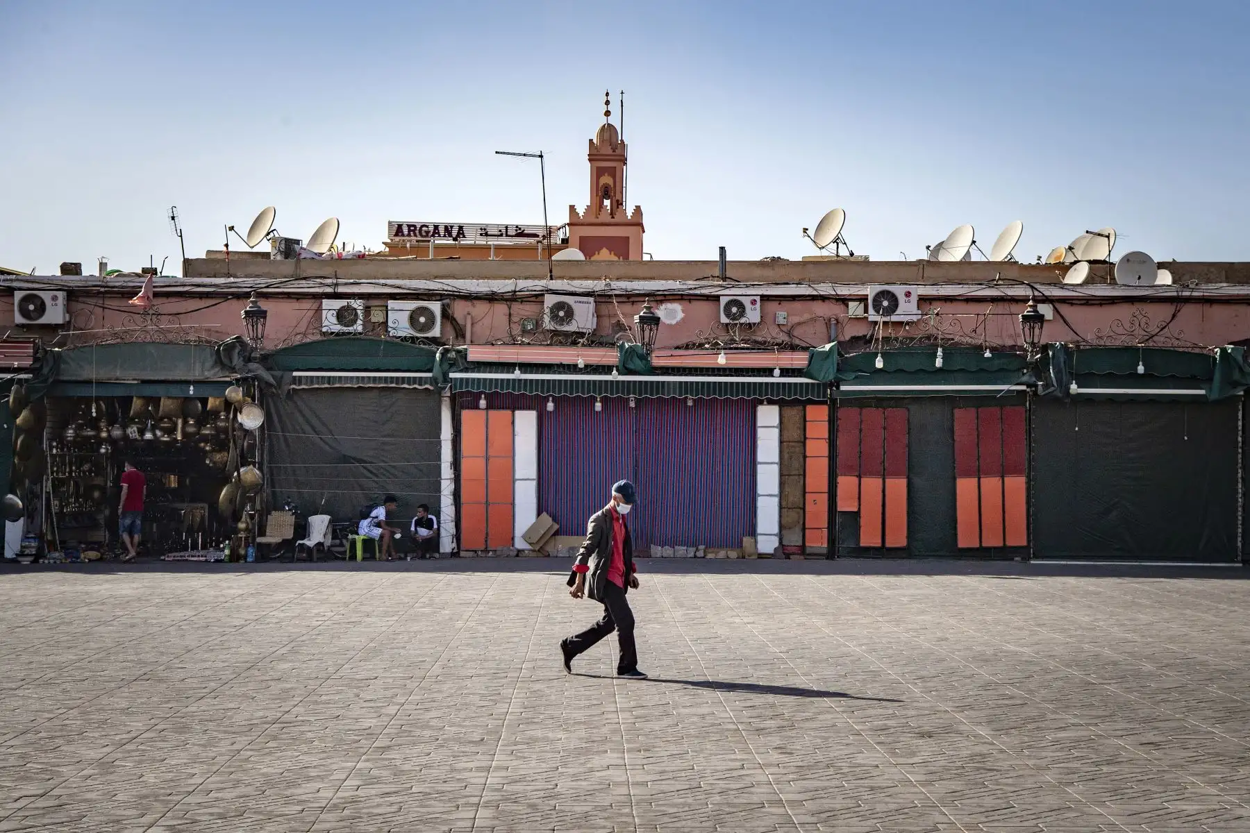 Un hombre camina por puestos en su mayoría cerrados en la plaza Jemaa el-Fna en la ciudad de Marrakech, en Marruecos. Foto: AFP