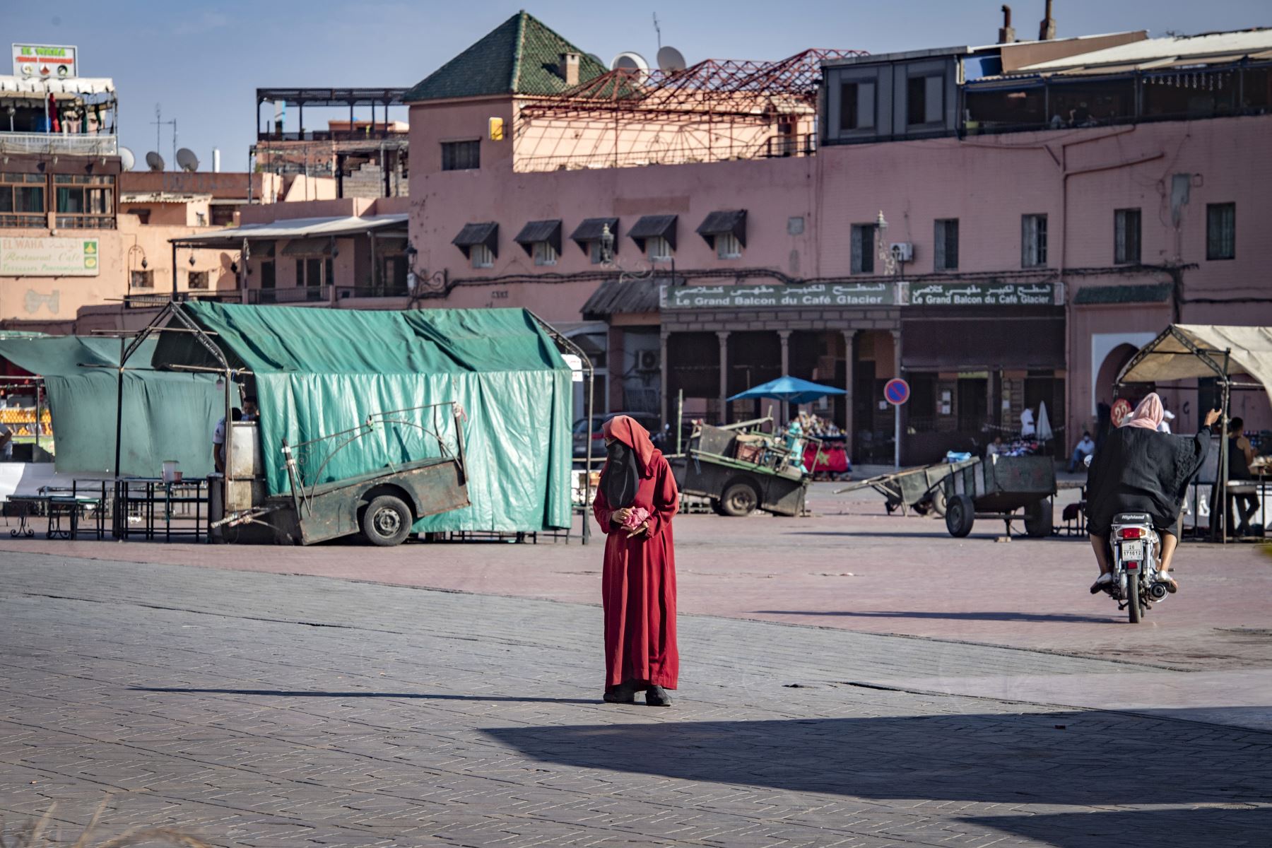 Una mujer mira mientras cruza la plaza Jemaa el-Fna en la ciudad marroquí de Marrakech, actualmente vacía de sus habituales multitudes debido a la pandemia de Covid-19. Foto: AFP