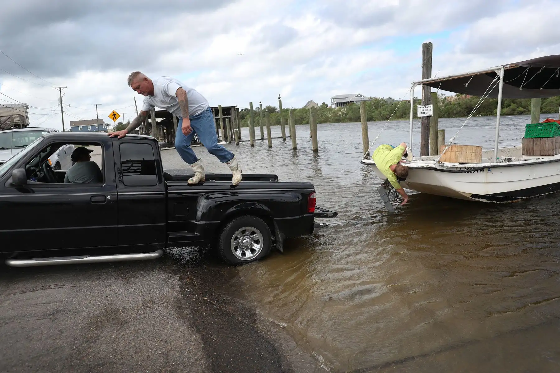 Dos personas intentan sacar su bote del agua antes de la posible llegada del huracán Sally en Shell Beach, Louisiana. Foto: AFP