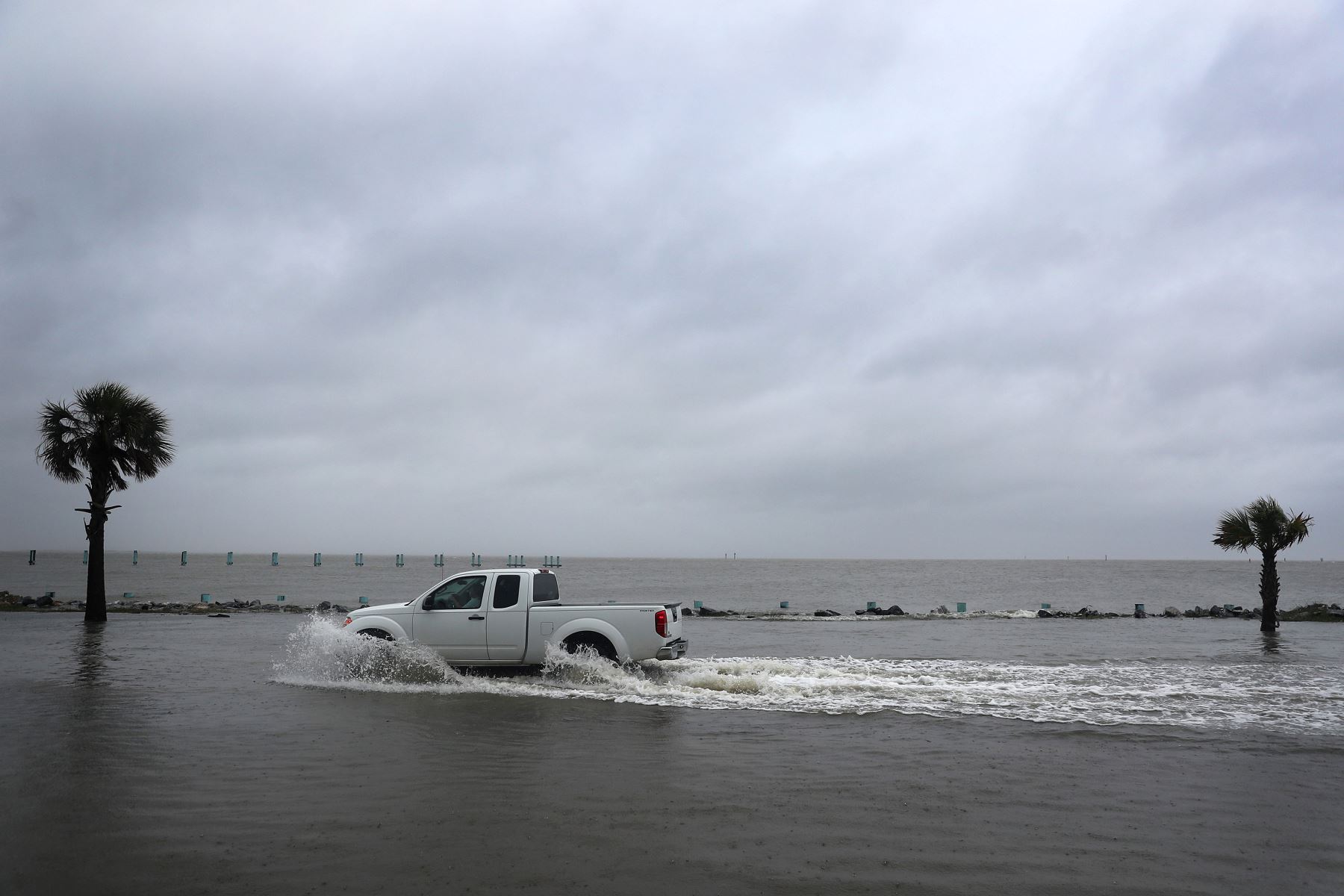 Un conductor navega a lo largo de una carretera inundada en Bayou La Batre, Alabama. Foto: AFP