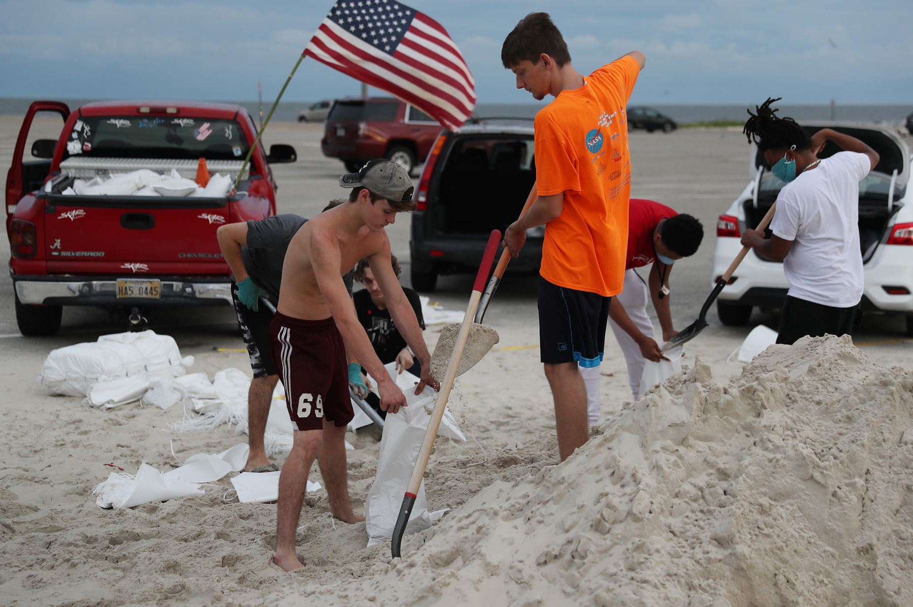 Jóvenes llenan sacos de arena en Biloxi, Mississippi, ante una posible llegada del huracán Sally. Foto: AFP