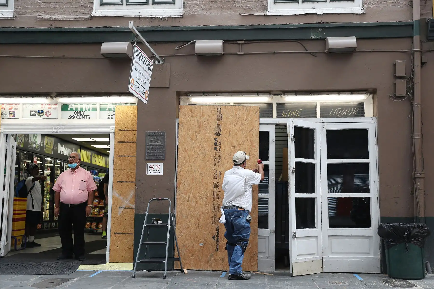 Un hombre coloca madera contrachapada sobre las ventanas de un negocio en el histórico Barrio Francés antes de la posible llegada del huracán Sally, en Nueva Orleans, Louisiana. Foto: AFP