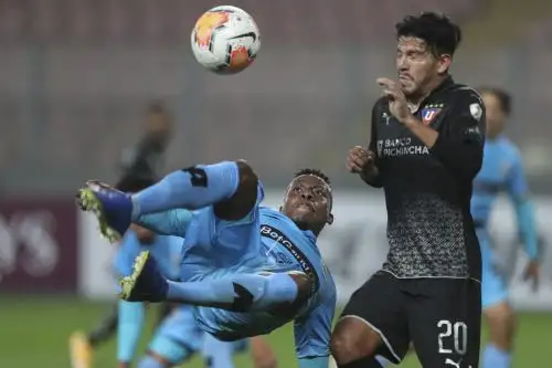 El defensor binacional de Perú Camilo Mancilla y el defensor de la Liga de Quito de Ecuador Christian Cruz compiten por el balón durante su partido de fútbol a puerta cerrada de la fase de grupos de la Copa Libertadores en el Estadio Nacional de Lima. Foto: AFP