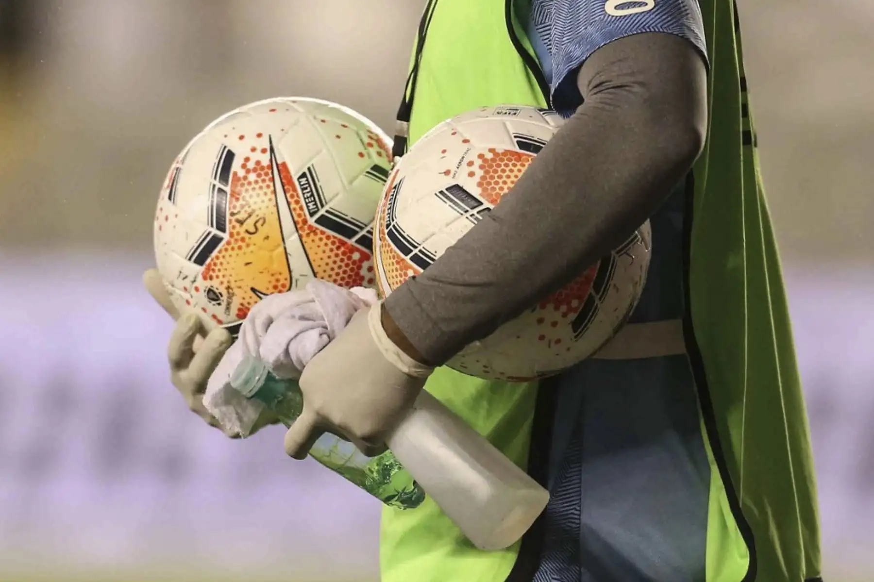 Un recogepelotas sostiene balones y desinfectante durante un partido de fútbol a puertas cerradas por la fase de grupos de la Copa Libertadores entre el Santos de Brasil y el Olimpia de Paraguay, en el estadio Vila Belmiro en Santos. Foto: AFP