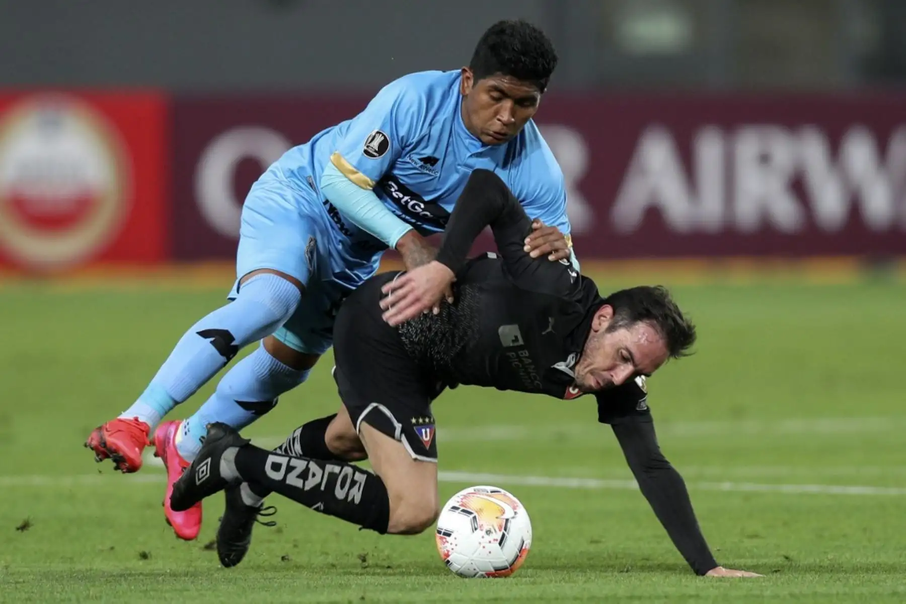 El mediocampista de Binacional de Perú, Pablo Labrin y el mediocampista de la Liga de Quito de Ecuador, Paul Zunino. compiten por el balón durante su partido de fútbol a puertas cerradas por la fase de grupos de la Copa Libertadores, en el Estadio Nacional de Lima. Foto: AFP