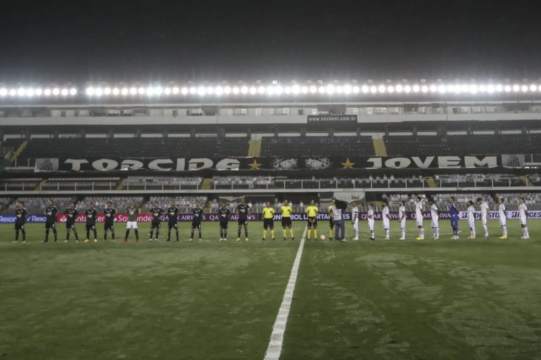 Los jugadores se forman en el campo antes de un partido de fútbol a puertas cerradas por la fase de grupos de la Copa Libertadores entre el Santos de Brasil y el Olimpia de Paraguay, en el estadio Vila Belmiro en Santos. Foto: AFP