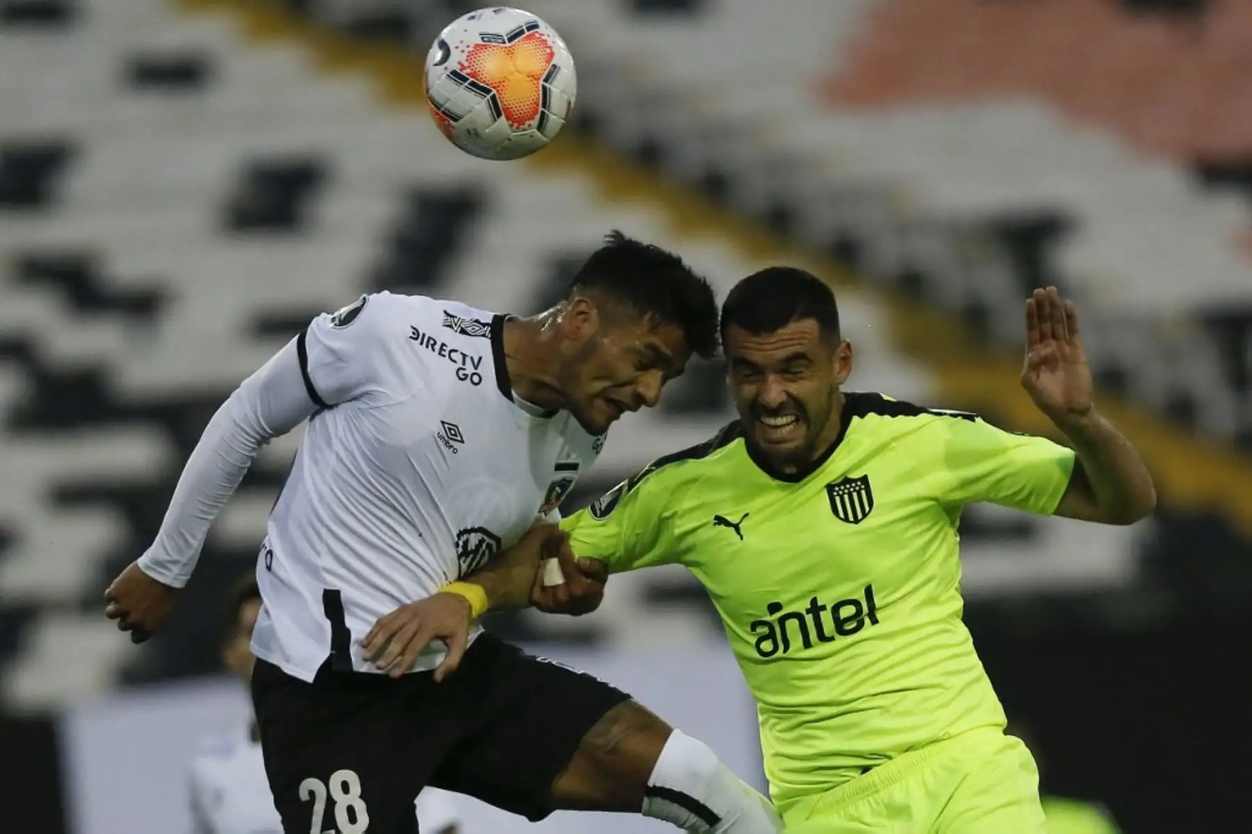 El defensor chileno del Colo Colo, Felipe Campos y el defensor uruguayo de Peñarol, Fabricio Formiliano, compiten por el balón durante el partido a puertas cerradas por la fase de grupos de la Copa Libertadores, en el estadio Monumental de Santiago. Foto: AFP