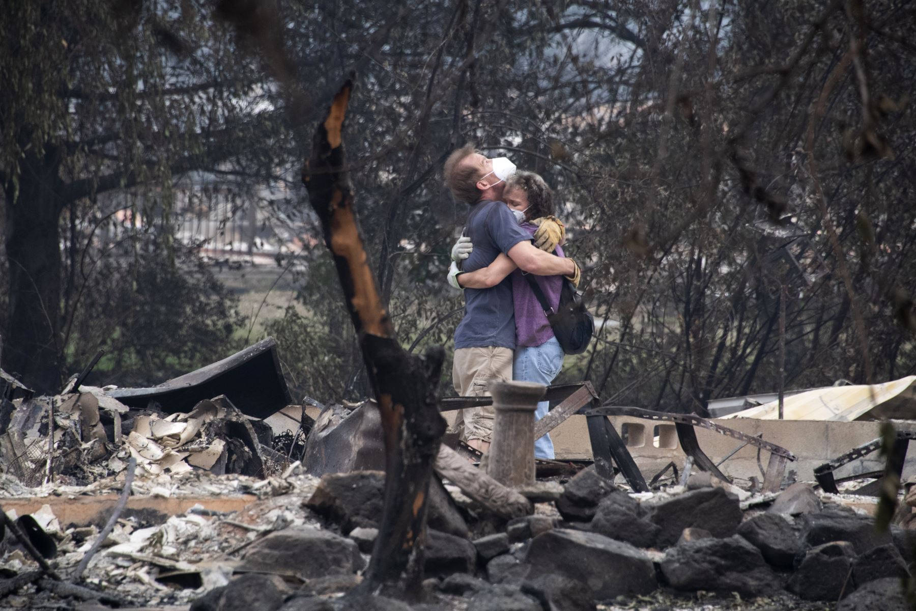 Dee Perez consuela a Michael Reynolds en las ruinas de su casa destruida tras el incendio de Almeda en Talent, Oregon. Foto: AFP