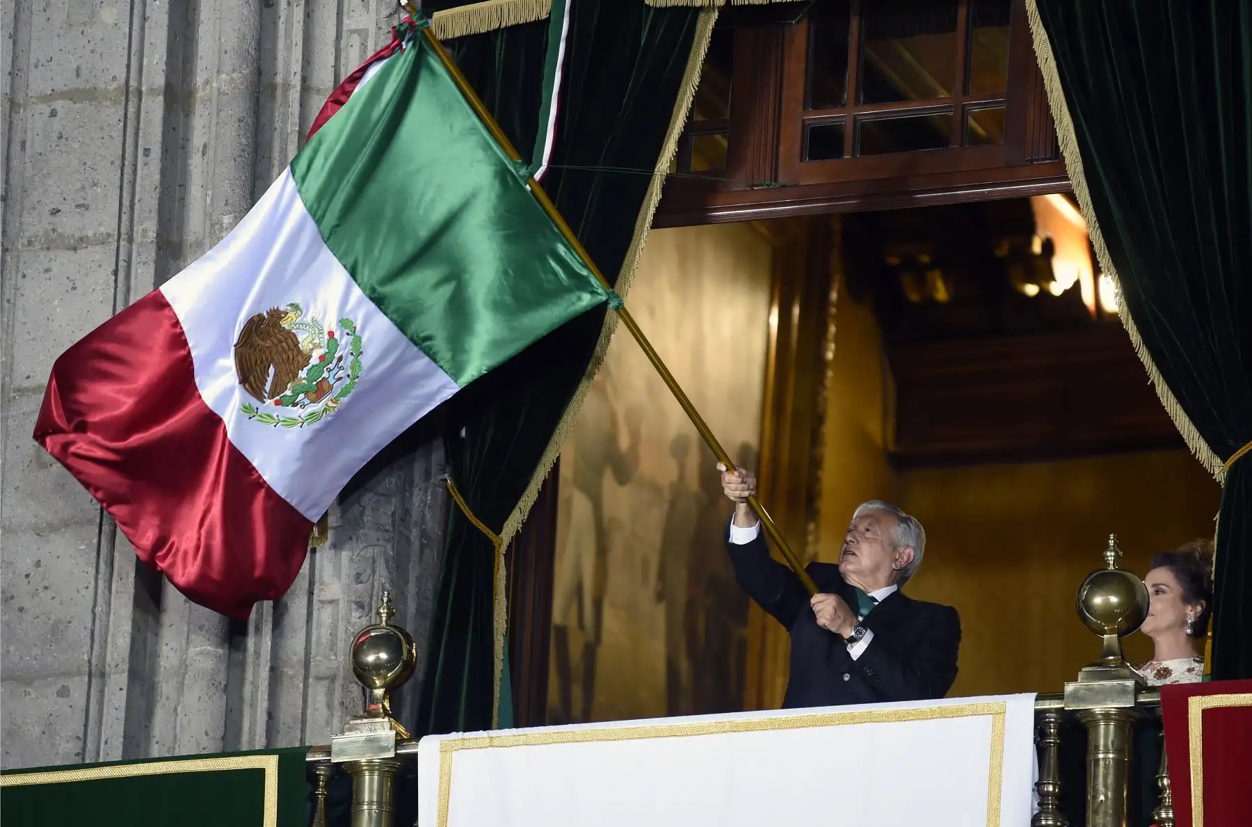 El presidente de México, Andrés Manuel López Obrador, ondea una bandera mexicana, flanqueada por su esposa Beatriz Gutiérrez, en el balcón principal del Palacio Nacional durante la ceremonia "El Grito" (El Grito) que marca el inicio de las celebraciones del Día de la Independencia en la Ciudad de México. Foto: AFP
