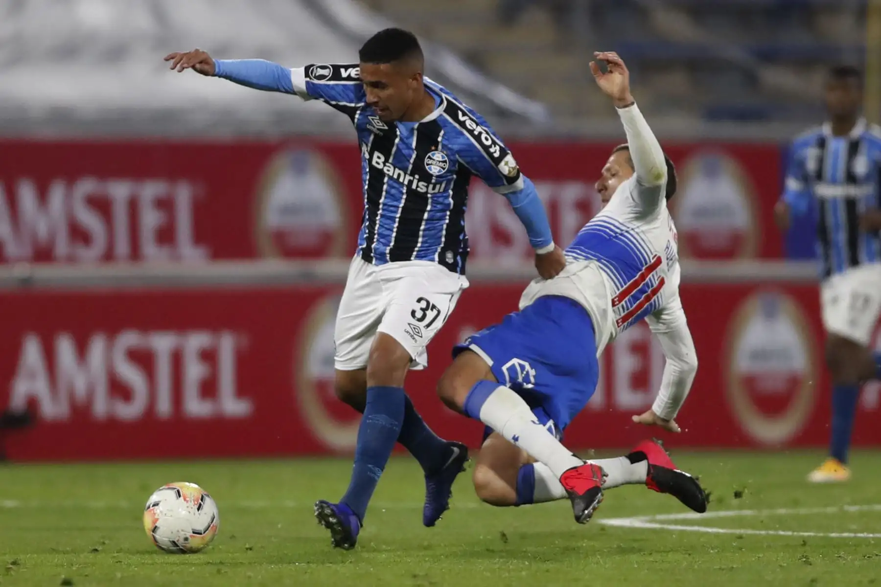 El mediocampista brasileño del Gremio Rildo y el mediocampista de la Universidad Católica de Chile, el argentino Luciano Aued, compiten por el balón durante el partido de fútbol a puerta cerrada de la fase de grupos de la Copa Libertadores en el estadio San Carlos de Apoquindo en Santiago. En el resulado Universidad Católica de Chile ganó 2  a 0 al Gremio.
Foto: AFP