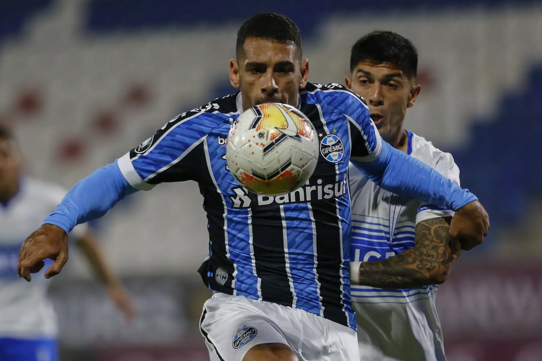 El delantero del Gremio de Brasil Diego Souza y el defensa de la Universidad Católica de Chile Valber Huerta compiten por el balón durante su partido de fútbol a puerta cerrada en la fase de grupos de la Copa Libertadores en el Estadio San Carlos de Apoquindo en Santiago.En el resulado Universidad Católica de Chile ganó 2  a 0 al Gremio.
Foto:AFP