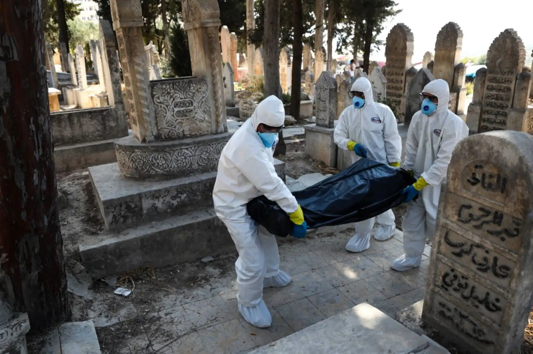 Trabajadores de salud con protectores llevan el cuerpo de un sirio desplazado de 62 años que murió de la enfermedad del covid-19, para ser enterrado en la ciudad de Salqin, en la provincia de Idlib, noroeste de Siria.Foto:AFP