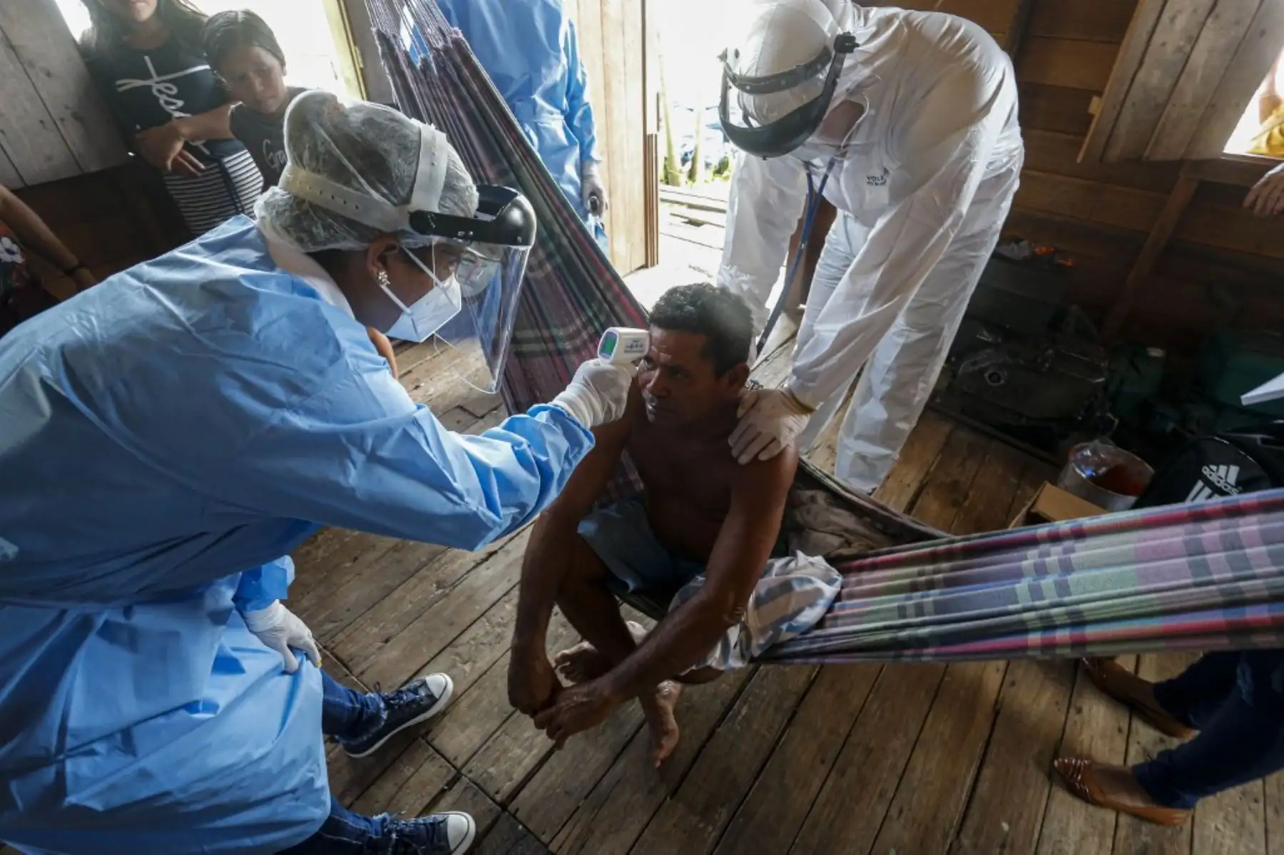 Trabajadores de salud del gobierno controlan la temperatura de un hombre en una comunidad ribereña del río Murutipucu en Igarape-Miri, Baixo Tocantins, en Brasil, para detectar casos de covid-19 entre la población.Foto:AFP