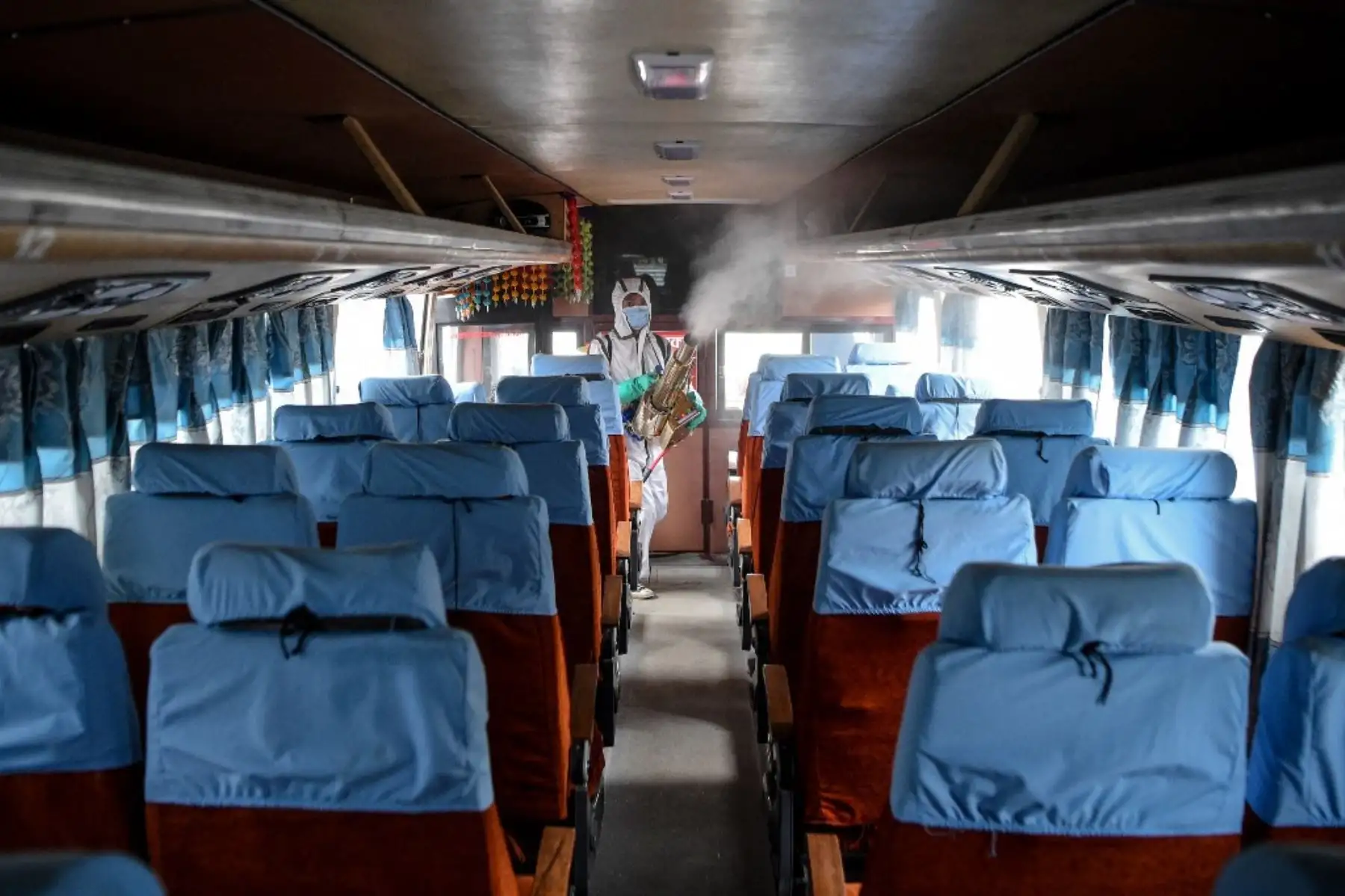 Un trabajador que lleva un equipo de protección personal sigue desinfectando un autobús mientras el gobierno suaviza las restricciones impuestas como medida preventiva contra el coronavirus en el transporte público de larga distancia en Katmandú.Foto:AFP