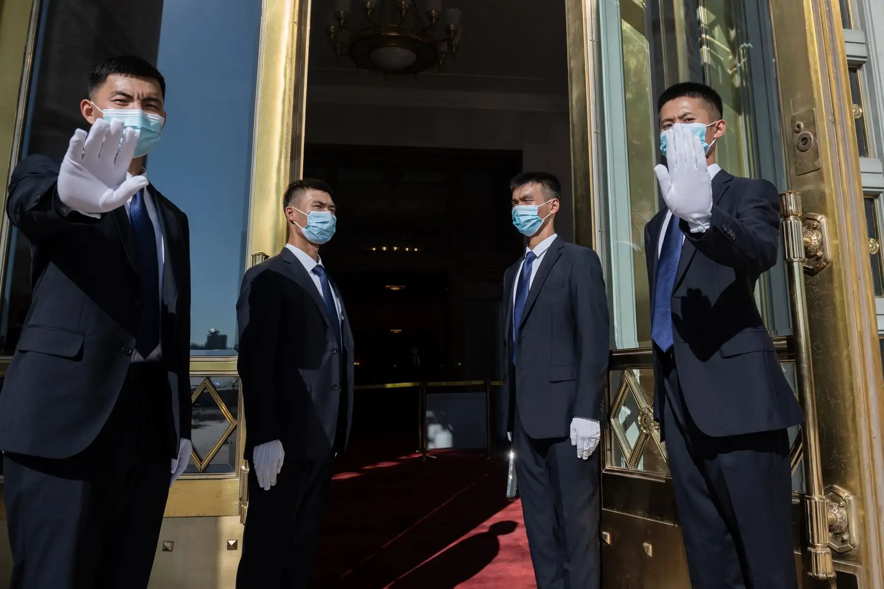 El personal de seguridad se para fuera del Gran Salón del Pueblo, donde realizan una ceremonia en honor a las personas que lucharon contra la pandemia del coronavirus, en Beijing. Foto: AFP
