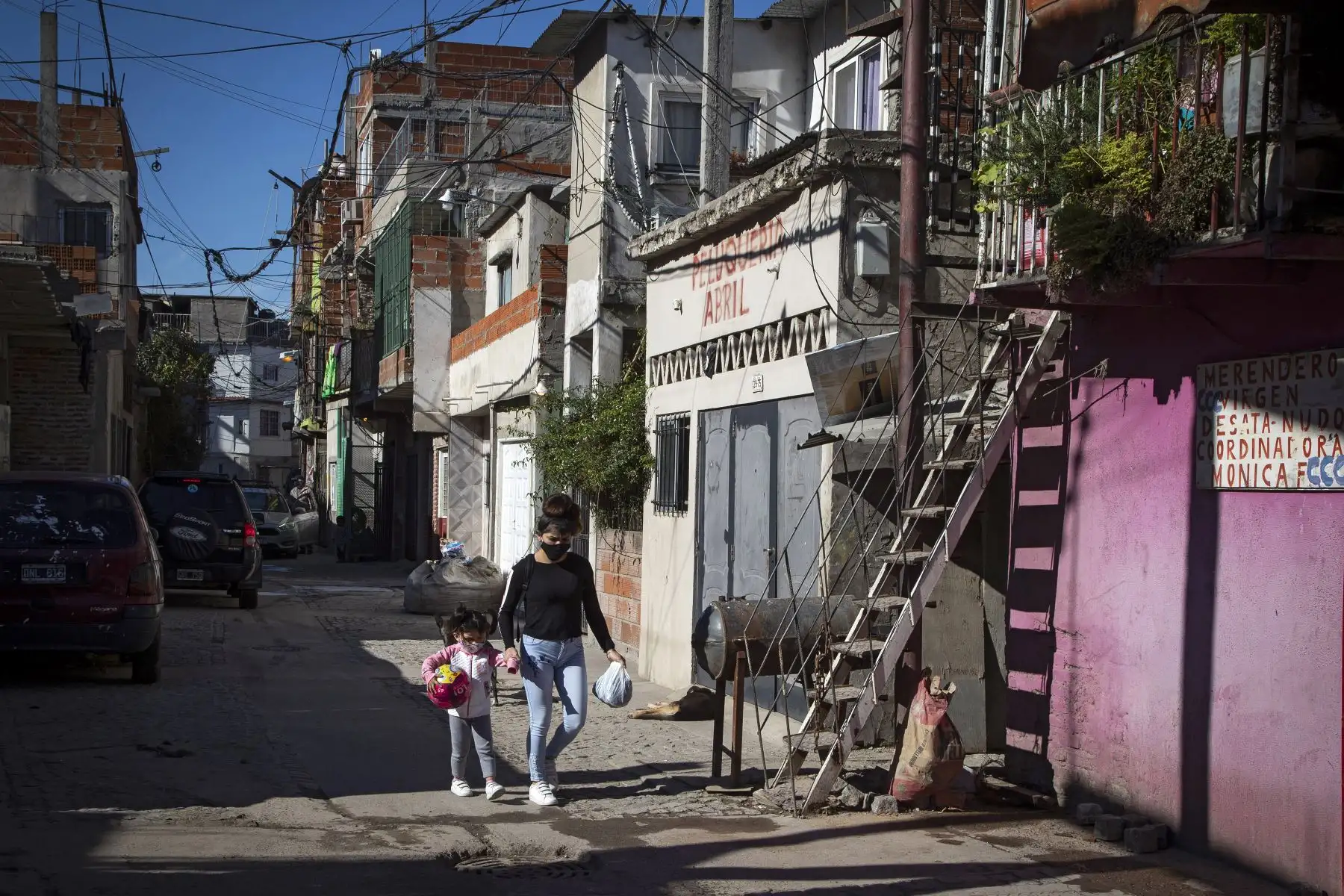 Una mujer y una niña caminan por un callejón en el barrio Padre Carlos Mugica, también conocido como Villa 31, en Buenos Aires. Foto: AFP