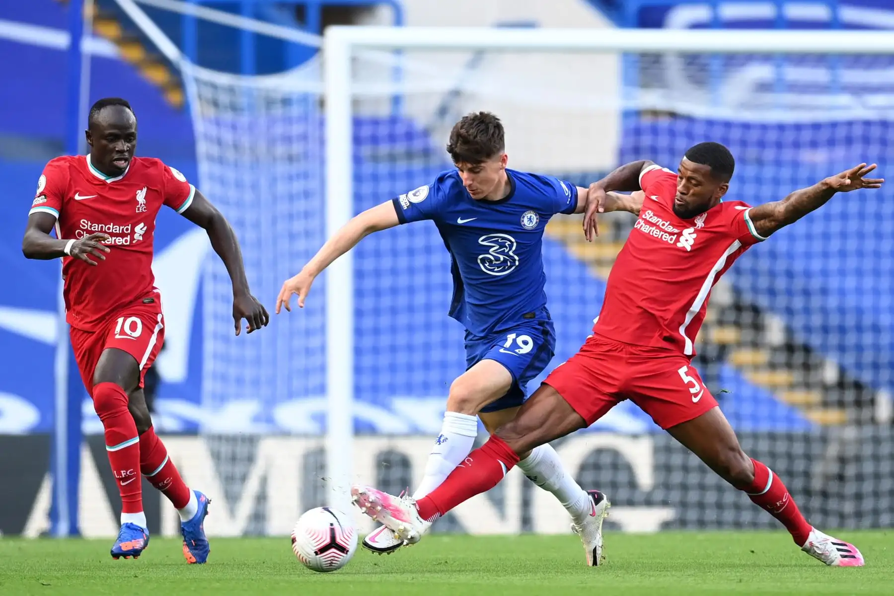 El mediocampista inglés de Chelsea, Mason Mount, es abordado por el mediocampista holandés de Liverpool, Georginio Wijnaldum, durante el partido de fútbol de la Premier League. Foto: AFP