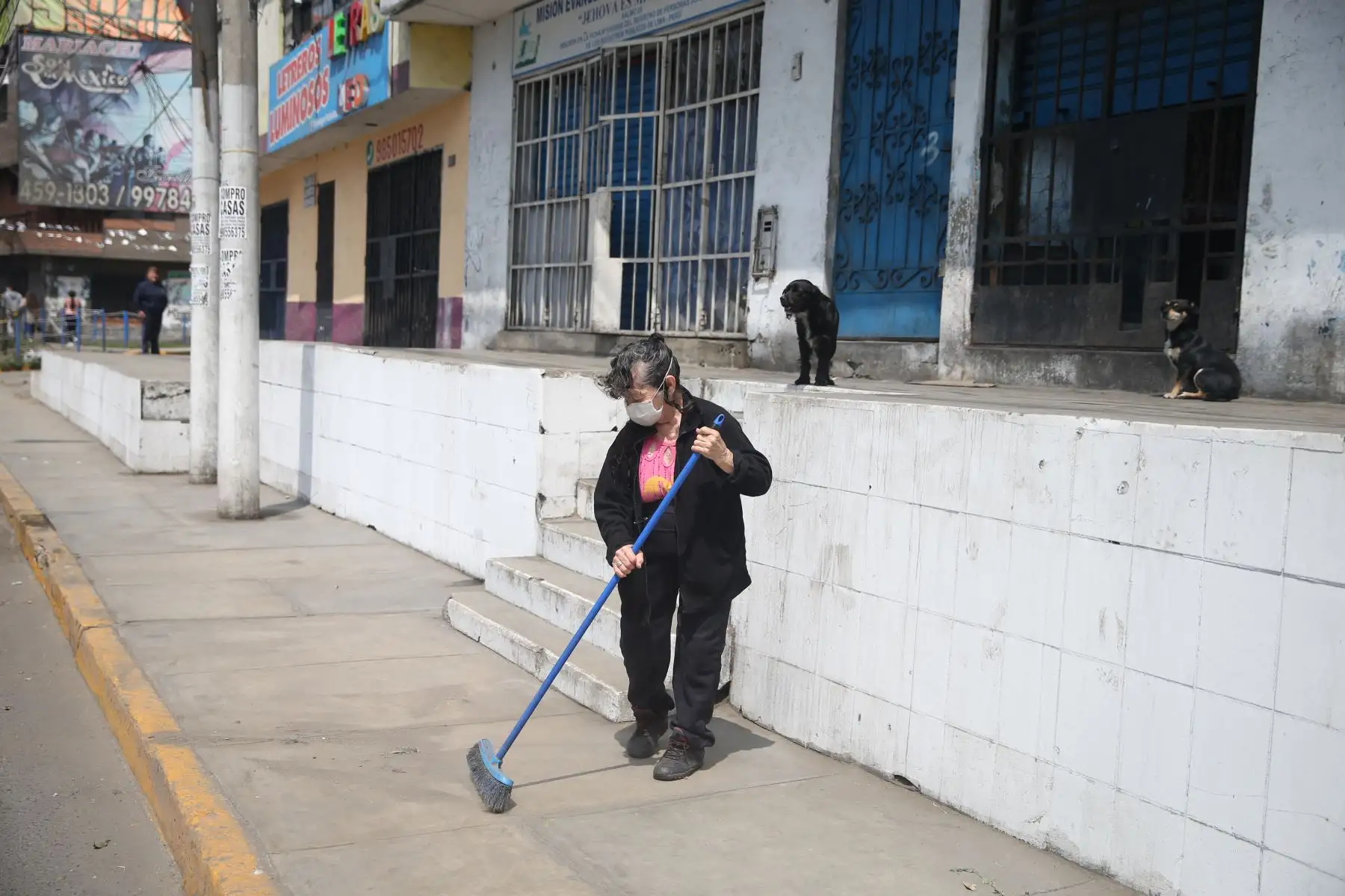 Una señora limpia los alrededores de su vivienda en San Juan de Lurigancho este domingo tras levantamiento de la inmovilización social obligatoria. Foto: ANDINA/Jhonel Rodríguez