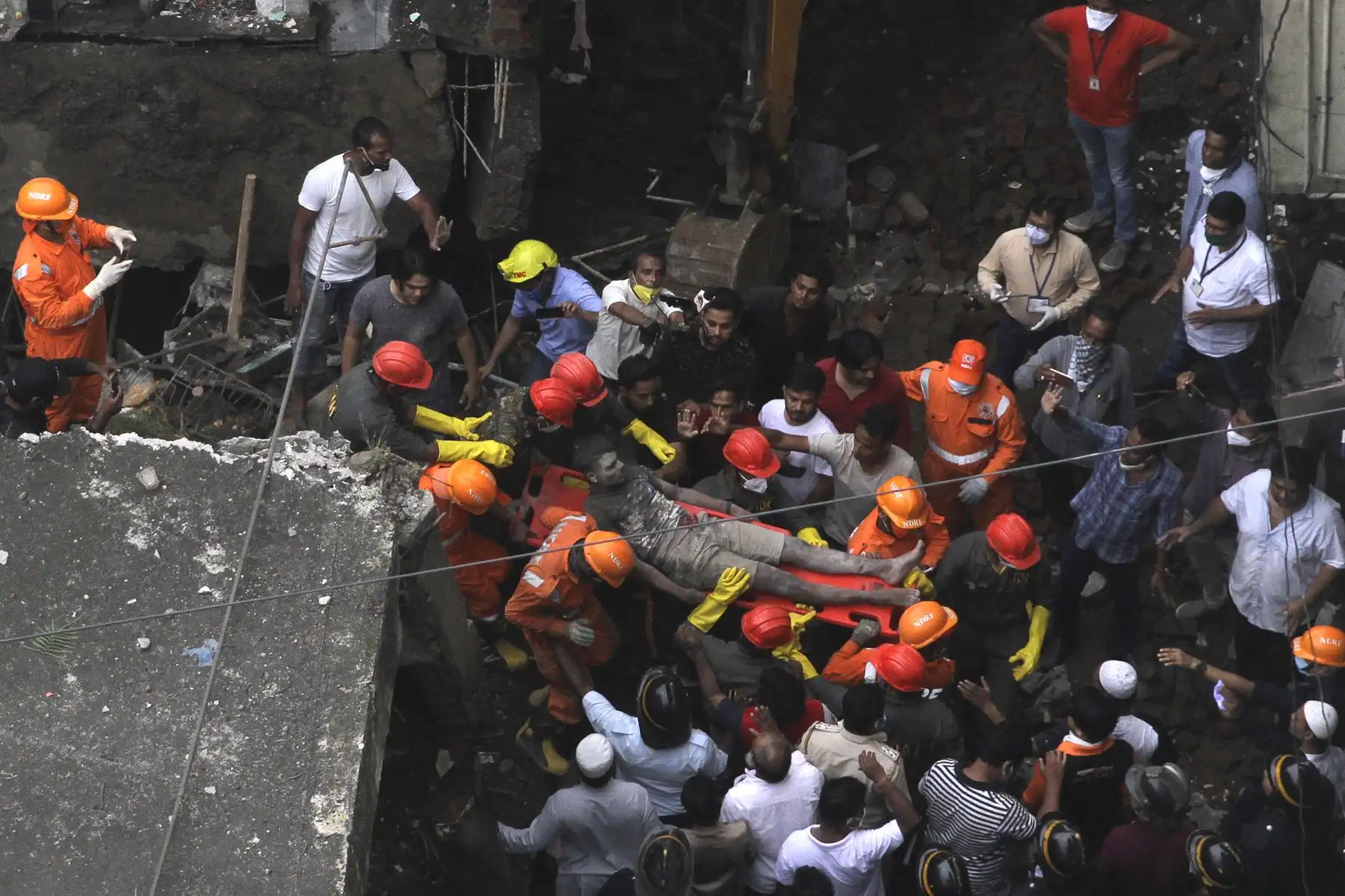 Los rescatistas trasladan a un sobreviviente de los escombros de un edificio residencial de tres pisos colapsado, en Bhiwandi, India. Foto: AFP