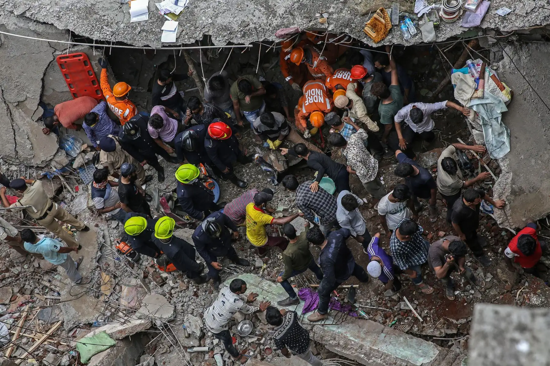 Las personas se reúnen para limpiar los escombros tras el colapso de un edificio residencial en Bhiwandi, en las afueras de Mumbai, India. Foto: EFE