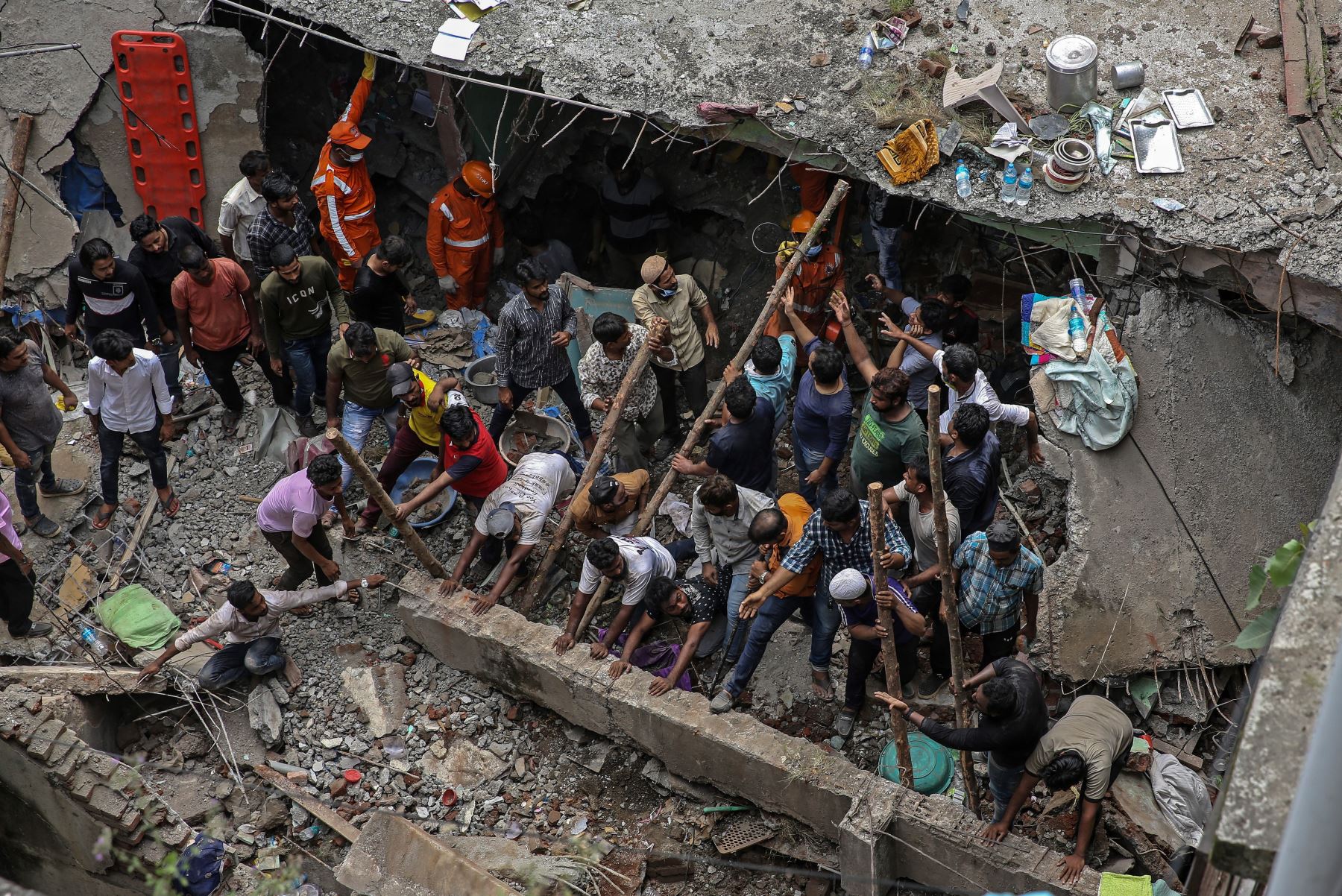 Las personas se reúnen para limpiar los escombros tras el colapso de un edificio residencial en Bhiwandi, en las afueras de Mumbai, India. Foto: EFE