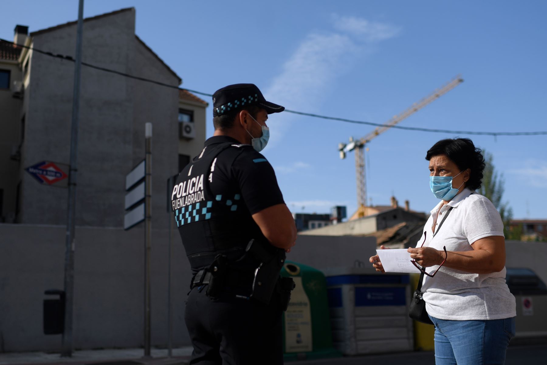 Una mujer habla con un policía durante control de desplazamiento de personas en la ciudad Fuenlabrada, en la región de Madrid, debido al rebrote de casos por coronavirus. Foto: AFP