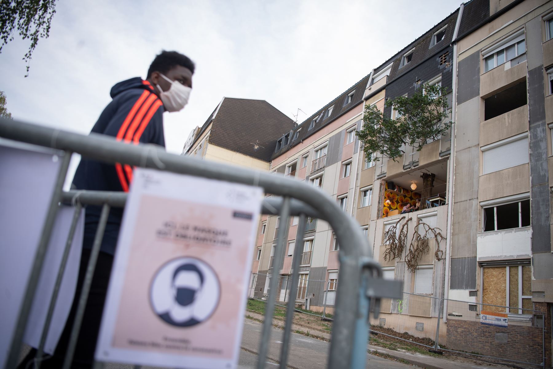 Un hombre con una mascarilla transita junto a un letrero que indica las reglas sanitarias a cumplir en el barrio de Bellevue, en Nantes, Francia. Foto: AFP