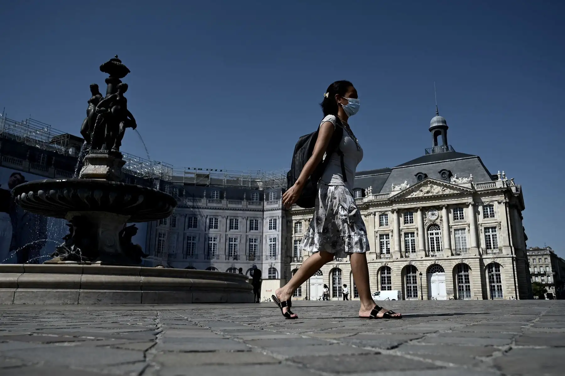 Una mujer con una máscara protectora para evitar la infección por coronavirus transita por la Place de la Bourse, en Burdeos, suroeste de Francia. Foto: AFP