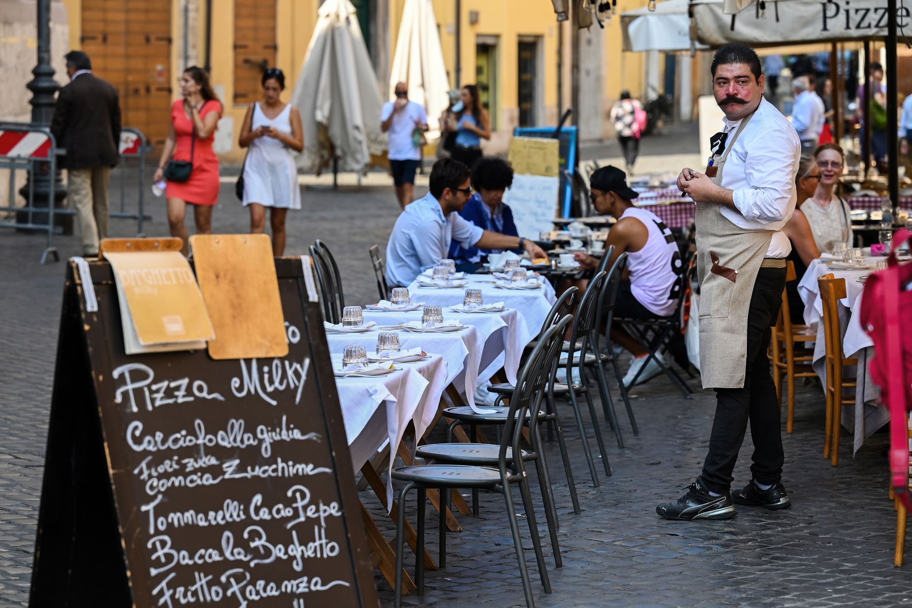 Un camarero observa la terraza de un restaurante en el barrio judío de Roma durante la pandemia por coronavirus. Foto: AFP