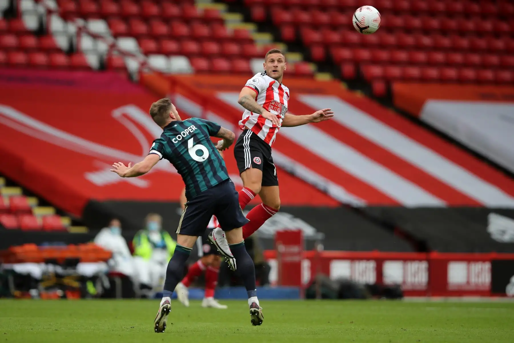 El defensor escocés de origen inglés del Leeds United, Liam Cooper, compite con el delantero inglés Billy Sharp del Sheffield United durante el partido de fútbol de la Premier League. Foto: AFP