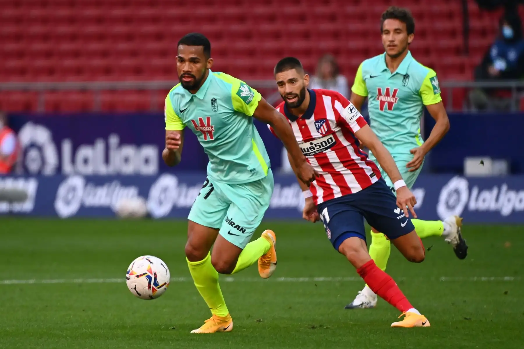 El mediocampista belga del Atlético de Madrid, Yannick Carrasco, desafía al mediocampista venezolano del Granada, Yangel Herrera, durante el partido de fútbol de la liga española. Foto: AFP