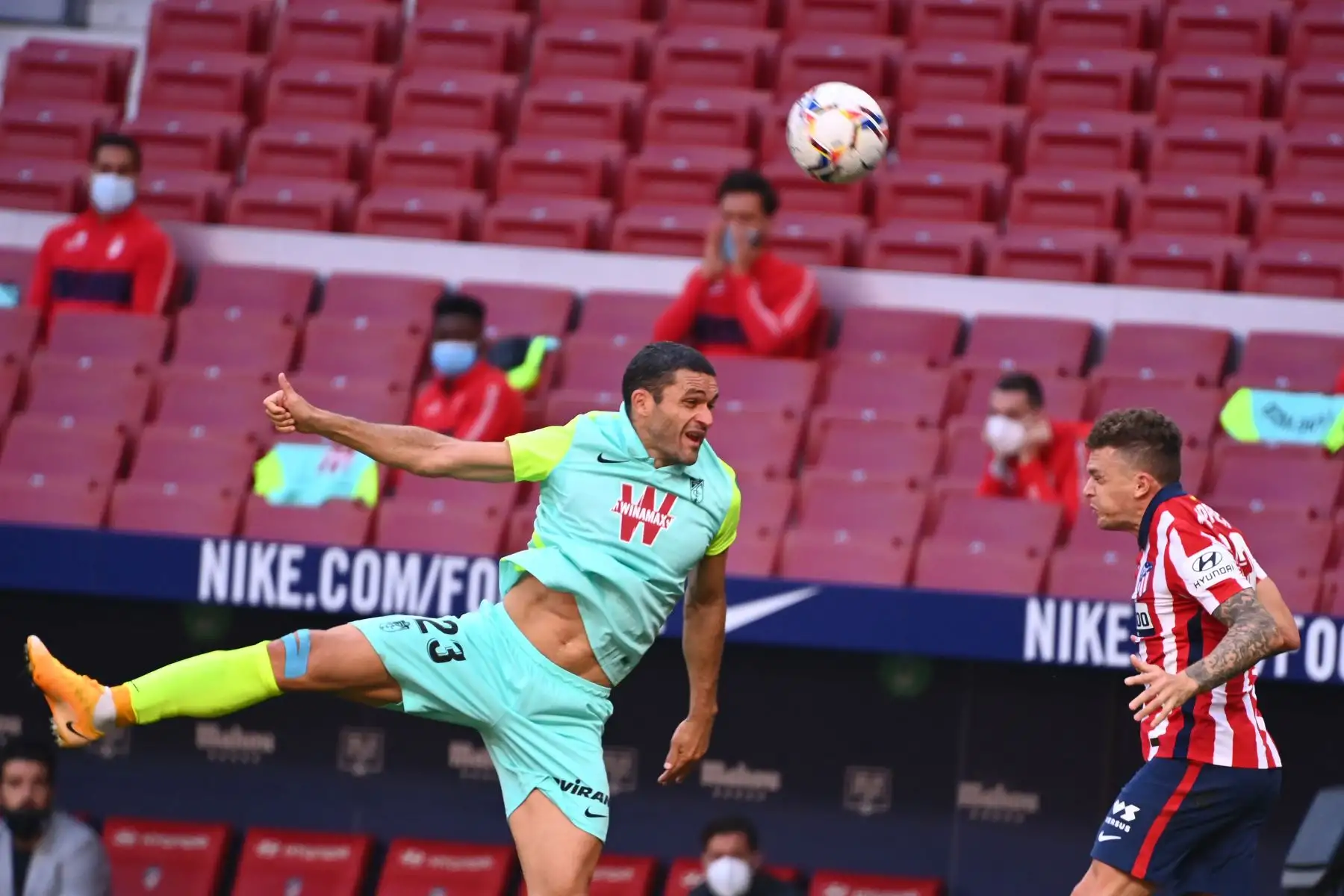 El delantero español de Granada Jorge Molina y el defensor inglés del Atlético de Madrid, Kieran Trippier, saltan por el balón durante el partido de fútbol de la liga española. Foto: AFP